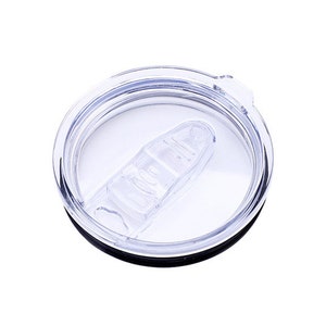 Puede incluir: Una tapa de pl&aacute;stico transparente con un borde negro y un peque&ntilde;o deslizador de pl&aacute;stico transparente. La tapa est&aacute; dise&ntilde;ada para una taza de viaje o un vaso.