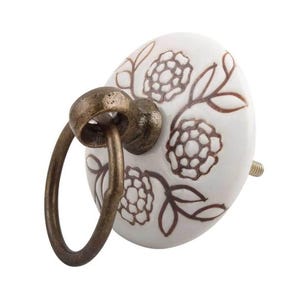 May include: White ceramic knob with a brown floral design and a brass ring. The knob has a screw on the back.