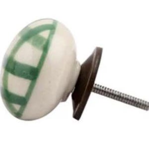 May include: White ceramic knob with a green striped design and a brown metal base. The knob has a threaded screw for attaching to a drawer or cabinet.