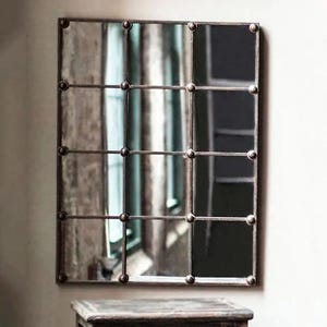 May include: A rectangular mirror with a metal frame divided into nine squares. The frame has decorative metal studs around each square.