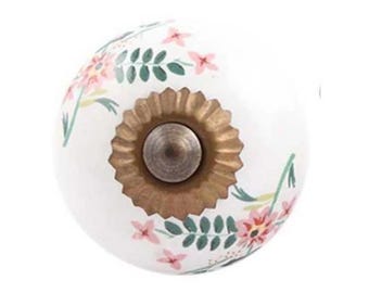 May include: White ceramic cabinet knob with a floral design in pink and green. The knob has a brass-colored base and a central screw. This decorative hardware is suitable for drawers and cabinets.