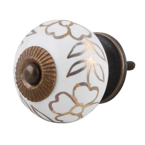 May include: White ceramic knob with gold floral design and a brass base.