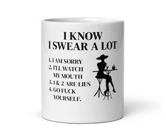 May include: White ceramic coffee mug with black text that reads "I know I swear a lot" and a list of four reasons why. The mug also features a black silhouette of a woman sitting at a table with a cup.