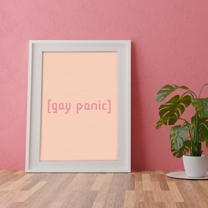 May include: A white framed picture with a peach background and the text "[gay panic]" in pink. A green potted plant sits on a wooden floor in front of the picture.