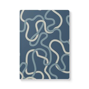 May include: A blue and white rope pattern on a notebook cover. The rope is intertwined and creates a nautical theme.