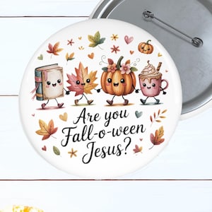 May include: A round pinback button featuring a white background with a cartoon illustration of a book, a maple leaf, a pumpkin, and a coffee cup holding hands. The text reads Are you Fall-o-ween Jesus? in black script, surrounded by small autumn leaves.