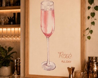 May include: A framed watercolor print featuring a tall, slender champagne flute filled with pink liquid. The artwork includes the text "Rosé" in a cursive script and "ALL DAY" in a simple, clean font positioned to the right of the glass.