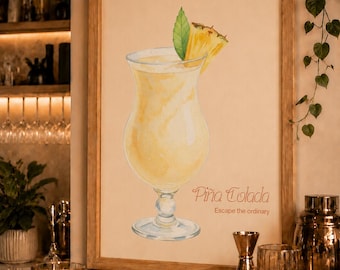 May include: A framed watercolor print featuring a yellow Pina Colada cocktail in a hurricane glass, garnished with a pineapple slice and a green leaf. The text reads Piña Colada and Escape the ordinary in a light brown script and sans-serif font.
