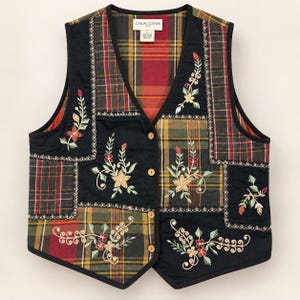 May include: A sleeveless waistcoat featuring a patchwork design of black fabric panels and red, green, and yellow plaid fabric. The waistcoat includes floral embroidery, four front buttons, and a Casual Corner label at the neckline indicating size L.