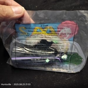 Puede incluir: Juguete Disney de McDonald's sellado en una bolsa de plástico transparente. El juguete parece ser un personaje de La Sirenita. La bolsa tiene texto impreso, incluida una advertencia sobre piezas pequeñas y el logotipo de Disney.