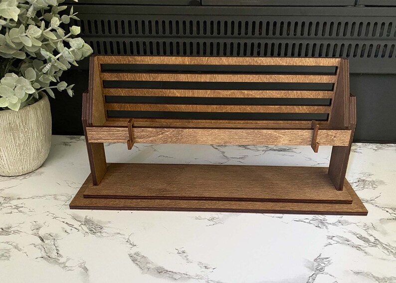 May include: A wooden bench with a slatted back and a shelf underneath. The bench is made of dark brown wood and has a natural wood finish.