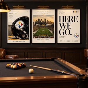 May include: Three framed wall art prints featuring Pittsburgh Steelers themes. The left print shows a black football helmet, the center print displays Acrisure Stadium, and the right print features the text HERE WE GO with the Steelers logo.