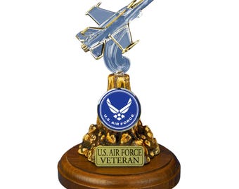Puede incluir: Una figurita de avión de combate F-16 de plata y oro sobre una base de madera. La base presenta un emblema de la Fuerza Aérea de los EE. UU. azul y dorado y una placa dorada que dice "U.S. Air Force Veteran".