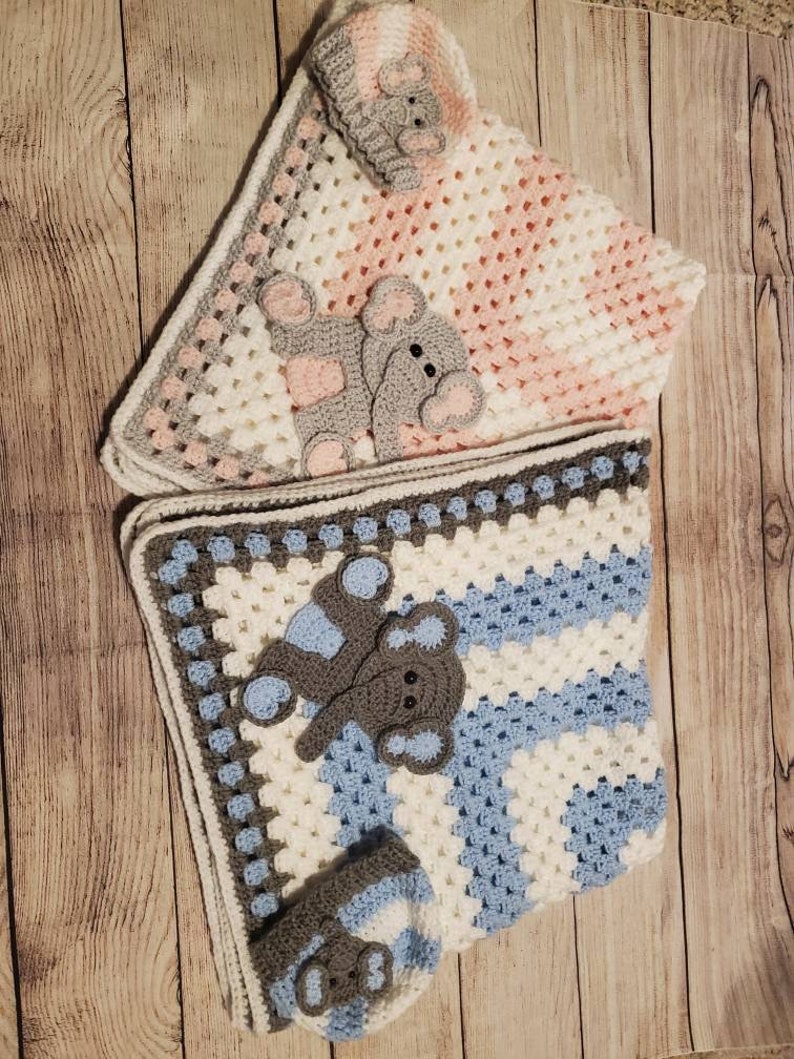 May include: Two crocheted baby blankets with matching hats. One blanket is pink and white with a gray elephant applique. The other blanket is blue and white with a gray elephant applique.
