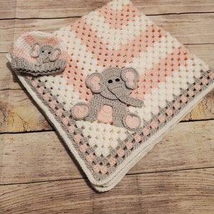 May include: A pink and white crocheted baby blanket with a gray crocheted elephant applique and a matching gray crocheted elephant hat.