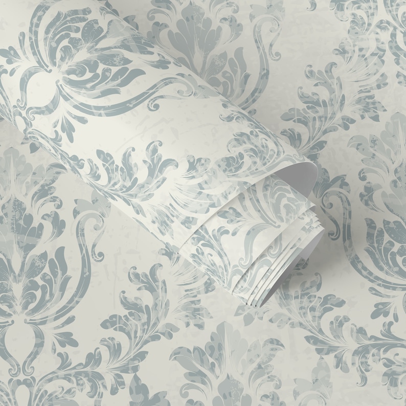 May include: A roll of blue and white patterned wallpaper with a damask design. The wallpaper is rolled up and the pattern is visible on the outside of the roll.