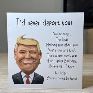 May include: A birthday card featuring a cartoon of a man with blonde hair and a red tie. The card's message is "I'd never deport you!" with additional text including "You're great. The best!" and "Have a great Birthday."