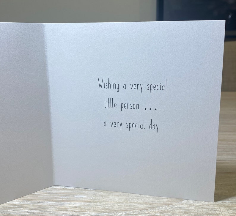 May include: A white card with black text that reads "Wishing a very special little person... a very special day."