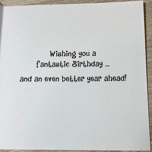 Pu&ograve; includere: Un biglietto bianco con testo nero che dice "Wishing you a fantastic Birthday... and an even better year ahead!"