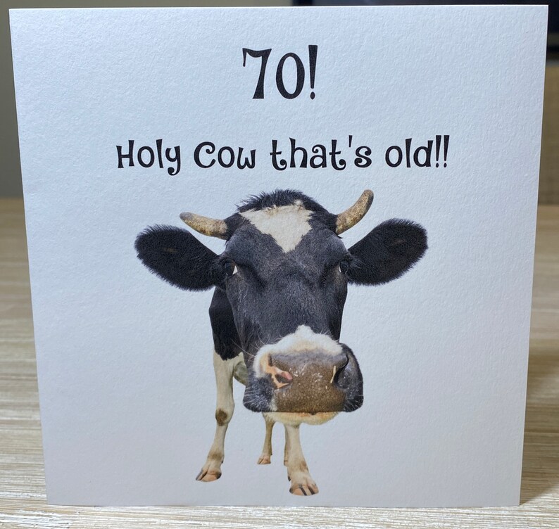 Pu&ograve; includere: Un biglietto di auguri di compleanno divertente con una mucca bianco e nero e il testo "70! Accidenti, che vecchio!"
