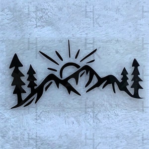 Könnte beinhalten: Schwarze Silhouette einer Bergkette mit einer aufgehenden Sonne dahinter. Zwei Kiefern stehen auf beiden Seiten der Berge.