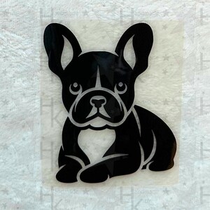 Könnte beinhalten: Schwarze und weiße Silhouette eines französischen Bulldoggen, der mit gekreuzten Pfoten sitzt. Der Hund blickt nach vorne und hat die Ohren aufgestellt.