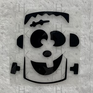 Könnte beinhalten: Schwarz-weißer Vinyl-Aufkleber eines Cartoon-Frankenstein-Monsters mit einem breiten Grinsen und Kulleraugen.