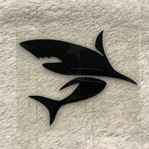 Könnte beinhalten: Schwarze Silhouette von zwei Haien, einer größer als der andere, die in die gleiche Richtung schwimmen. Der größere Hai befindet sich über dem kleineren.
