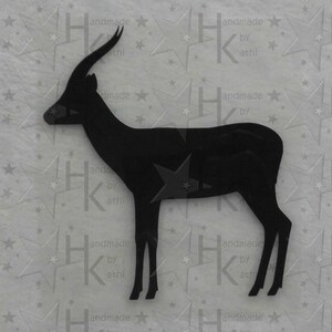 Könnte beinhalten: Schwarze Silhouette einer Gazelle mit langen, gebogenen Hörnern. Die Gazelle steht auf einem weißen Hintergrund mit einem sich wiederholenden Muster aus Sternen.