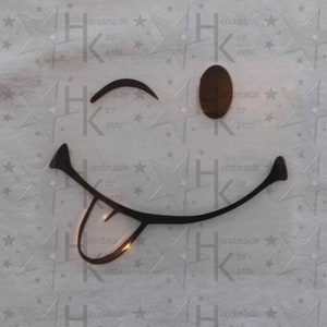 Könnte beinhalten: Ein schwarz-weißes Smiley-Gesicht mit herausgestreckter Zunge, das mit einem Auge zwinkert. Das Smiley-Gesicht befindet sich auf einem weißen Hintergrund mit einem sich wiederholenden Muster aus Sternen und dem Text "handmade by athi".