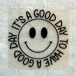Könnte beinhalten: Ein schwarz-weißer Aufkleber mit einem Smiley und dem Text "Es ist ein guter Tag, um einen guten Tag zu haben".