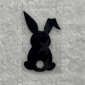 Könnte beinhalten: Schwarze Silhouette eines Kaninchens mit langen Ohren, stehend auf weißem Hintergrund.