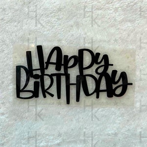 Könnte beinhalten: Schwarzer Acryl-Kuchentopper mit den Worten "Happy Birthday" in einer kursivschrift.