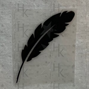 Könnte beinhalten: Schwarze Federsilhouette auf weißem Hintergrund mit einem sich wiederholenden Muster aus Sternen und dem Text "handmade by athl" im Hintergrund.