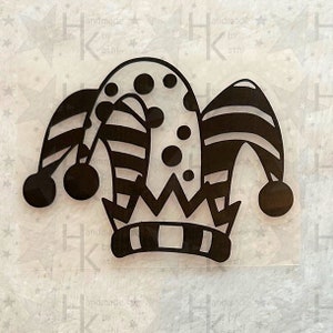 Könnte beinhalten: Schwarz-weiße Narrenkappe mit einem gestreiften Muster und einer Krone. Die Kappe hat drei Glöckchen an den Enden der Spitzen.