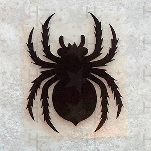 Könnte beinhalten: Schwarze Silhouette einer Spinne mit acht Beinen und einem großen Körper. Die Spinne ist nach vorne gerichtet, die Beine sind ausgestreckt.