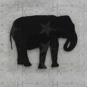 Könnte beinhalten: Schwarze Silhouette eines Elefanten, der auf allen vieren steht und seinen Rüssel eingerollt hat. Der Elefant ist aus einem festen Material ausgeschnitten und hat eine glatte, matte Oberfläche.