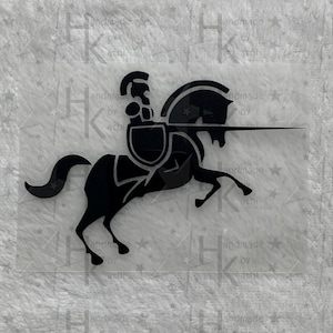 Könnte beinhalten: Schwarze Silhouette eines Ritters, der auf einem Pferd reitet, eine Lanze hält und einen Schild am Arm trägt.