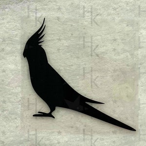 Könnte beinhalten: Schwarze Silhouette eines Nymphensittichs. Der Vogel ist im Profil, mit einem langen Schwanz und einem ausgeprägten Kamm. Das Bild befindet sich auf einem transparenten Hintergrund mit dem Text "handmade by athi" wiederholt.