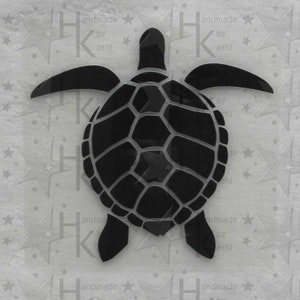 Könnte beinhalten: Schwarze Silhouette einer Meeresschildkröte mit detailliertem Panzerdesign. Die Schildkröte blickt dem Betrachter entgegen, Kopf und Beine sind sichtbar.