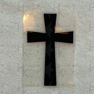 Könnte beinhalten: Ein schwarzes Kreuz mit Sternmuster, vor transparentem Hintergrund. Das Kreuz ist ein schlichtes, klassisches Design, mit einem vertikalen Balken, der von einem horizontalen Balken gekreuzt wird. Das Sternmuster fügt ein dekoratives Element hinzu.