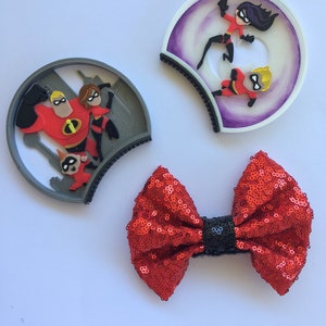 May include: A pair of gray and purple mouse ears with a red bow. The mouse ears feature a 3D image of the Incredibles family. The bow is made of red sequins with a black center.
