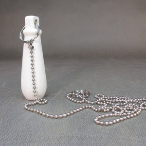 Peut inclure: Chaîne de traction de réservoir de toilette en céramique blanche avec une chaîne en métal argenté.