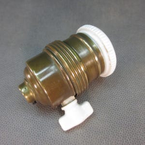 Peut inclure: Une douille de lampe en laiton avec un interrupteur en porcelaine blanche et un dessus en porcelaine blanche.