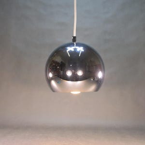 May include: A chrome pendant light fixture with a round, reflective shade.