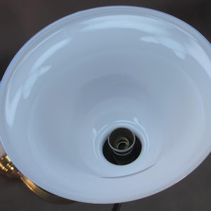 May include: A white glass lampshade with a white porcelain socket and a brass base.