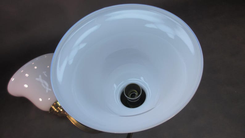 May include: A white glass lampshade with a white porcelain socket and a brass base.