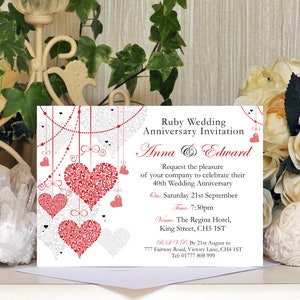 May include: A white invitation card with red and grey hearts hanging from a string of pearls. The text reads "Ruby Wedding Anniversary Invitation Anna & Edward Request the pleasure of your company to celebrate their 40th Wedding Anniversary On: Saturday 21st September Time: 7:30pm Venue: The Regina Hotel, King Street, CH5 1ST R.S.V.P. By 21st August to 777 Fairway Road, Victory Lane, CH4 1ST Tel: 01777 808 999"