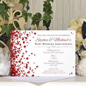 May include: A white invitation card with red ruby-like accents, announcing Sophia & Michael's Ruby Wedding Anniversary. The text includes the date, time, and location: Victoria Hotel, Brighton, CH1 4ST. RSVP details are also provided.