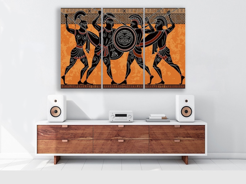 May include: A triptych canvas print featuring a black and white illustration of three Greek warriors in a battle scene. The warriors are depicted in a black silhouette against an orange background with a geometric pattern.